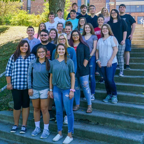 Honor students gathered on a set of steps outside