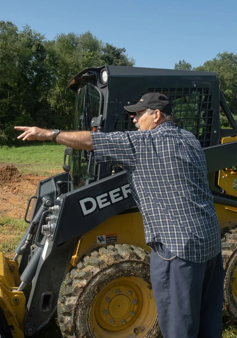Instructor pointing to what a student should do with the heavy equipment on a jobsite.